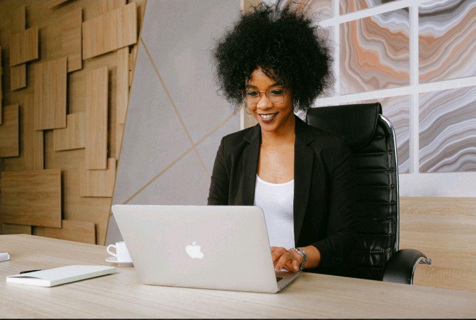 A woman sitting at a table with a laptop.