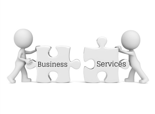 Two people are holding a puzzle piece that says business and services.